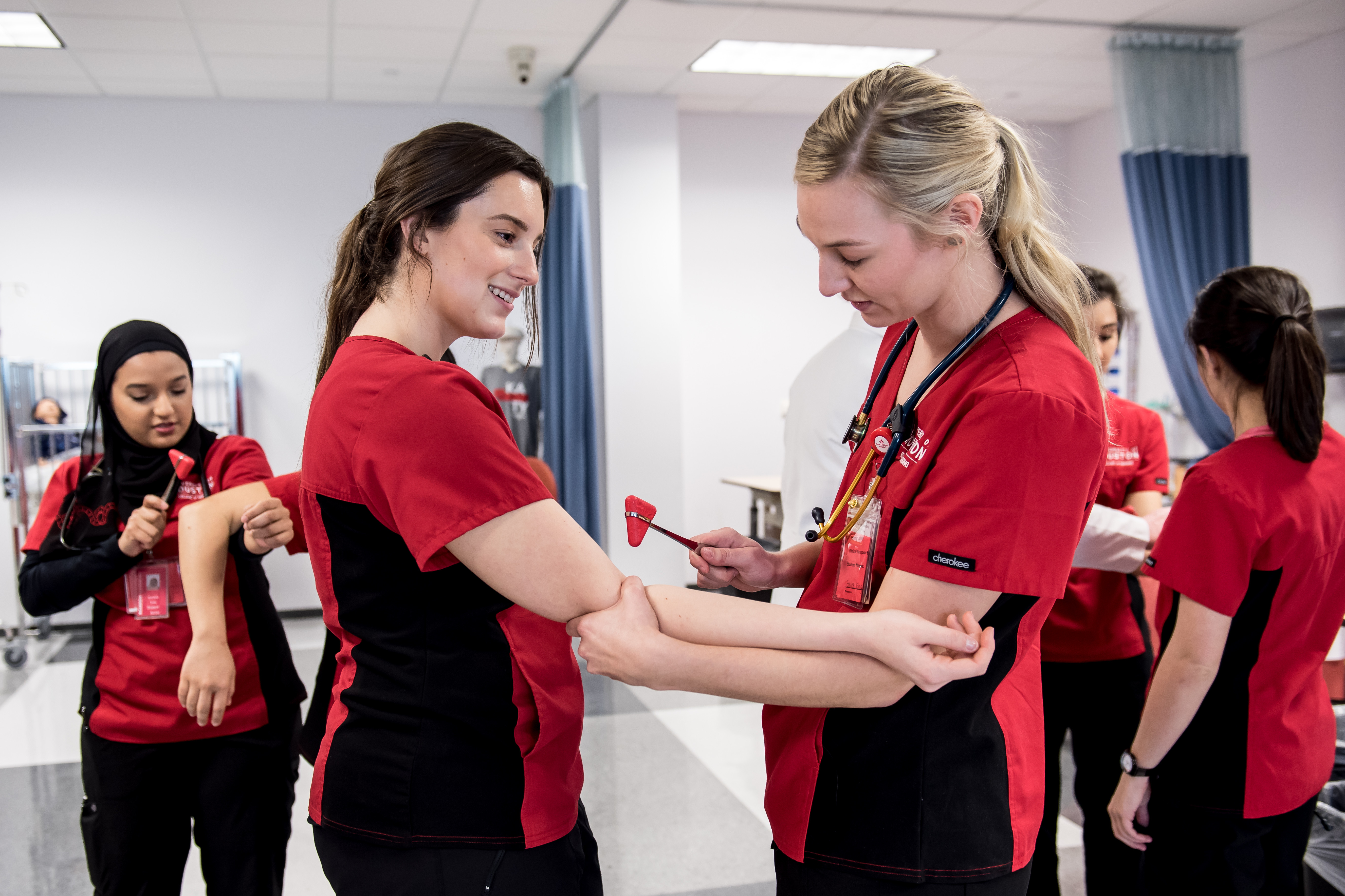 Nurse students practicing on each other for reflexes